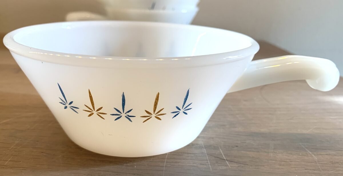 <p>Soepkom / soeptas - met handvat - Fire King Anchor Hocking - wit melkglas met blauw/geel decor</p> - Brocante