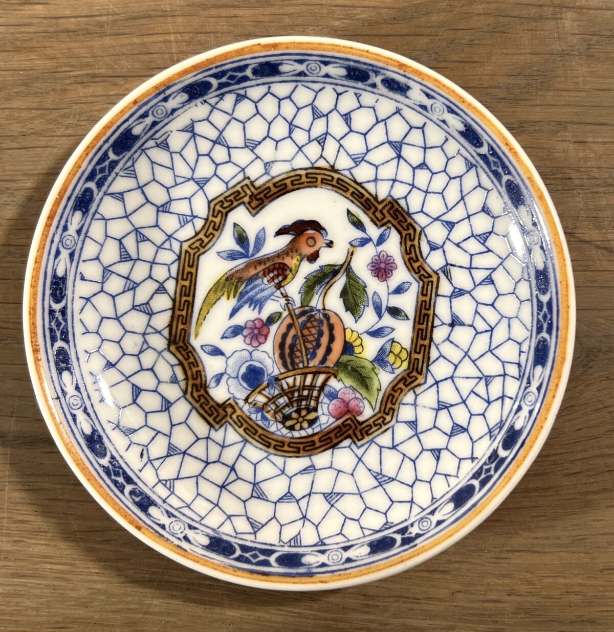 <p>Schotel - klein formaat (kinderserviesje?) - Mosa/Louis Regout - décor van papegaai binnenin rand met netdecor</p> - Mosa