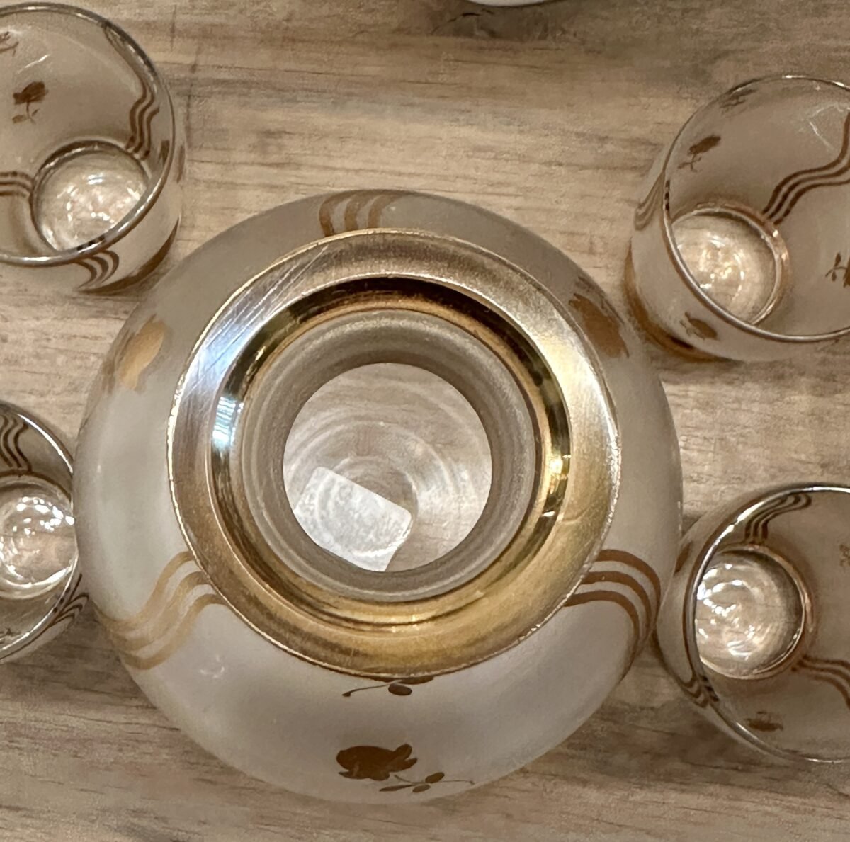 <p>Likeurset - karaf met 5 glaasjes - waarschijnlijk Booms glas van de Rupel - uitgevoerd in mat glas met goudkleurige beschildering</p> - Brocante