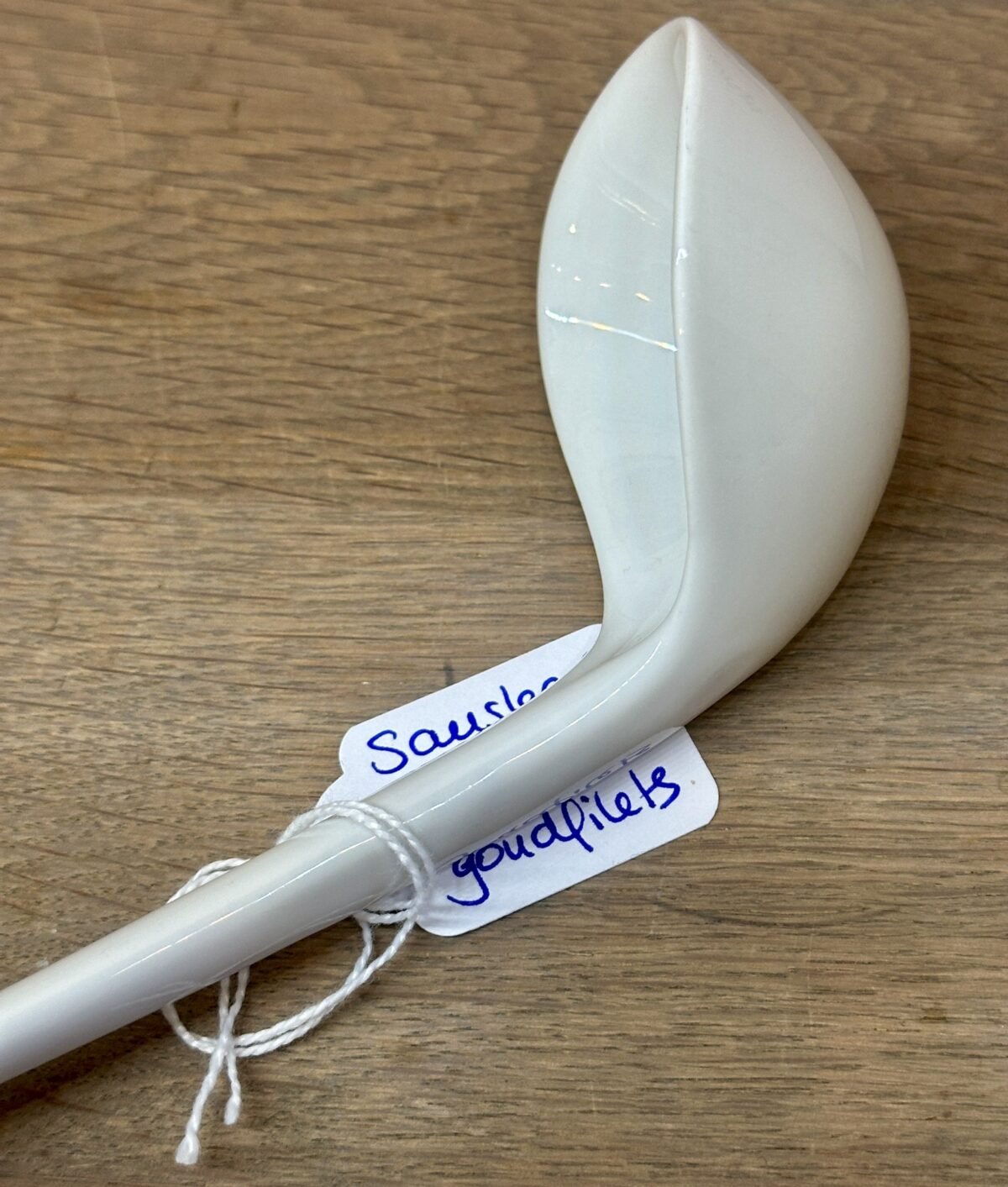 <p>Sauslepel / Lepel - ongemerkt - porselein uitgevoerd in wit met goudkleurige filets</p> - Onbekend