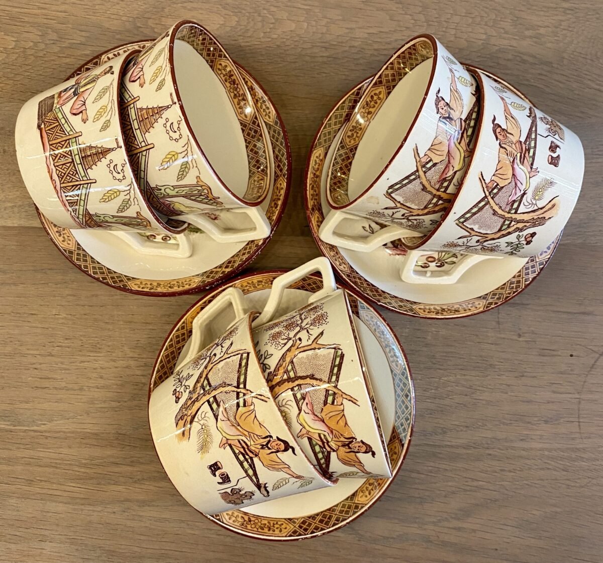 <p>Kop en schotel - iets wijder uitlopend model kopje met hoekig oortje en diep schoteltje - ongemerkt (Sarreguemines?) - decor TIMOR L.</p> - Onbekend