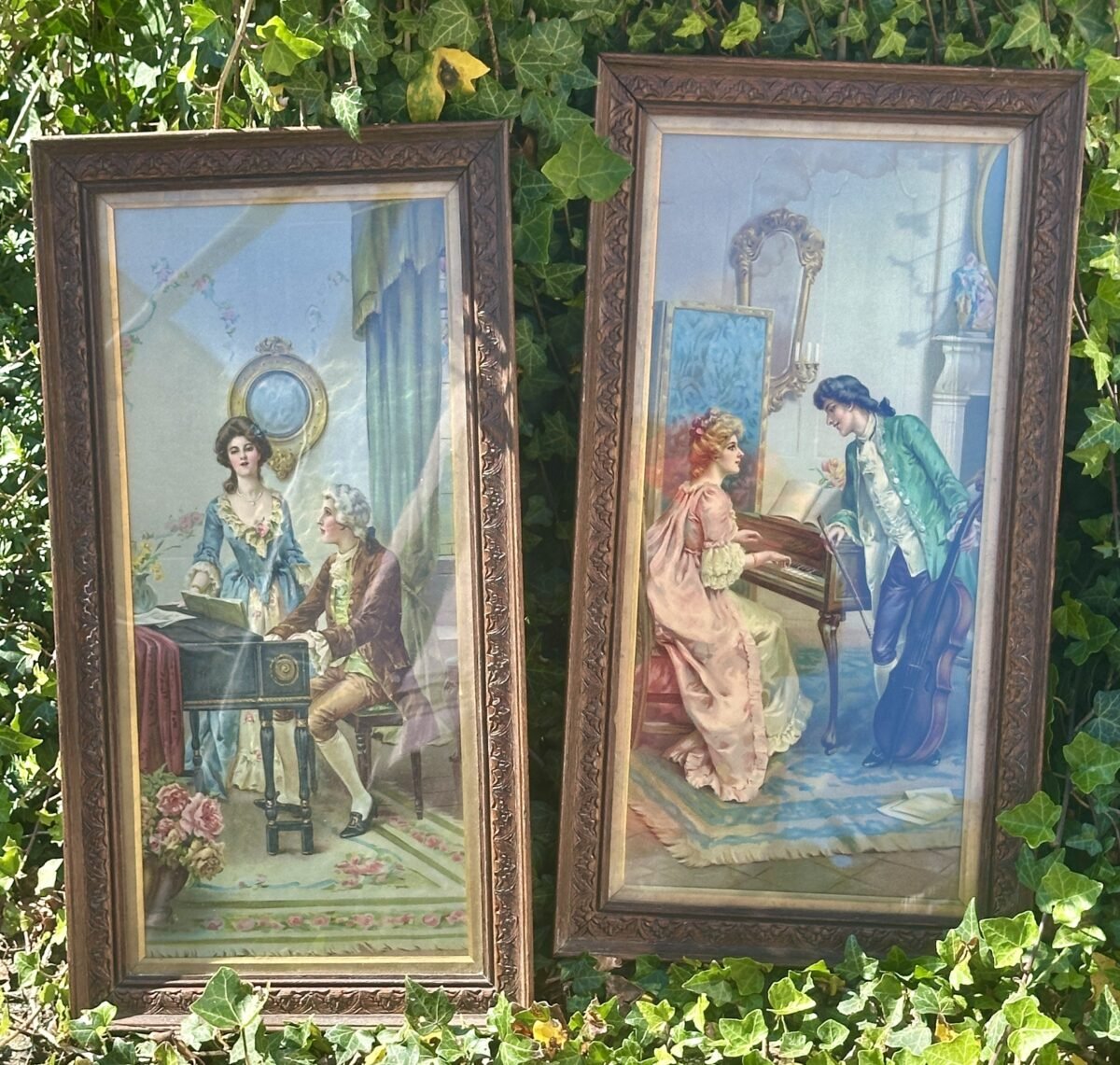 <p>Plaat in oblong houten lijst met afbeelding van een man aan een klavecimbel/piano met dame in blauwe jurk</p> - Brocante