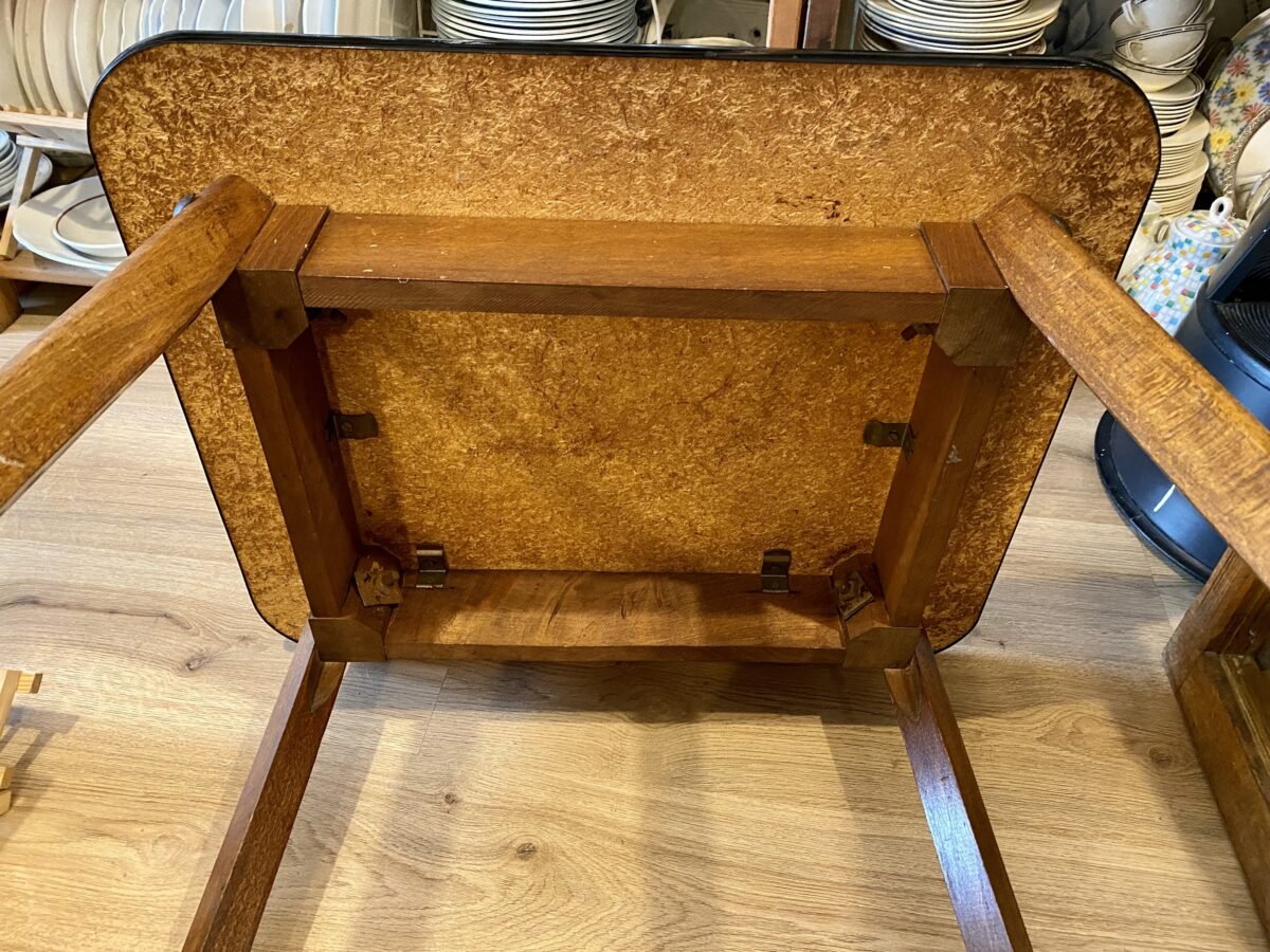 <p>TV-tafel / Bijzettafel op wieltjes - houten poten - donkerrood (skai) blad en extra afzetmogelijkheid onderaan - Vintage</p> - Brocante