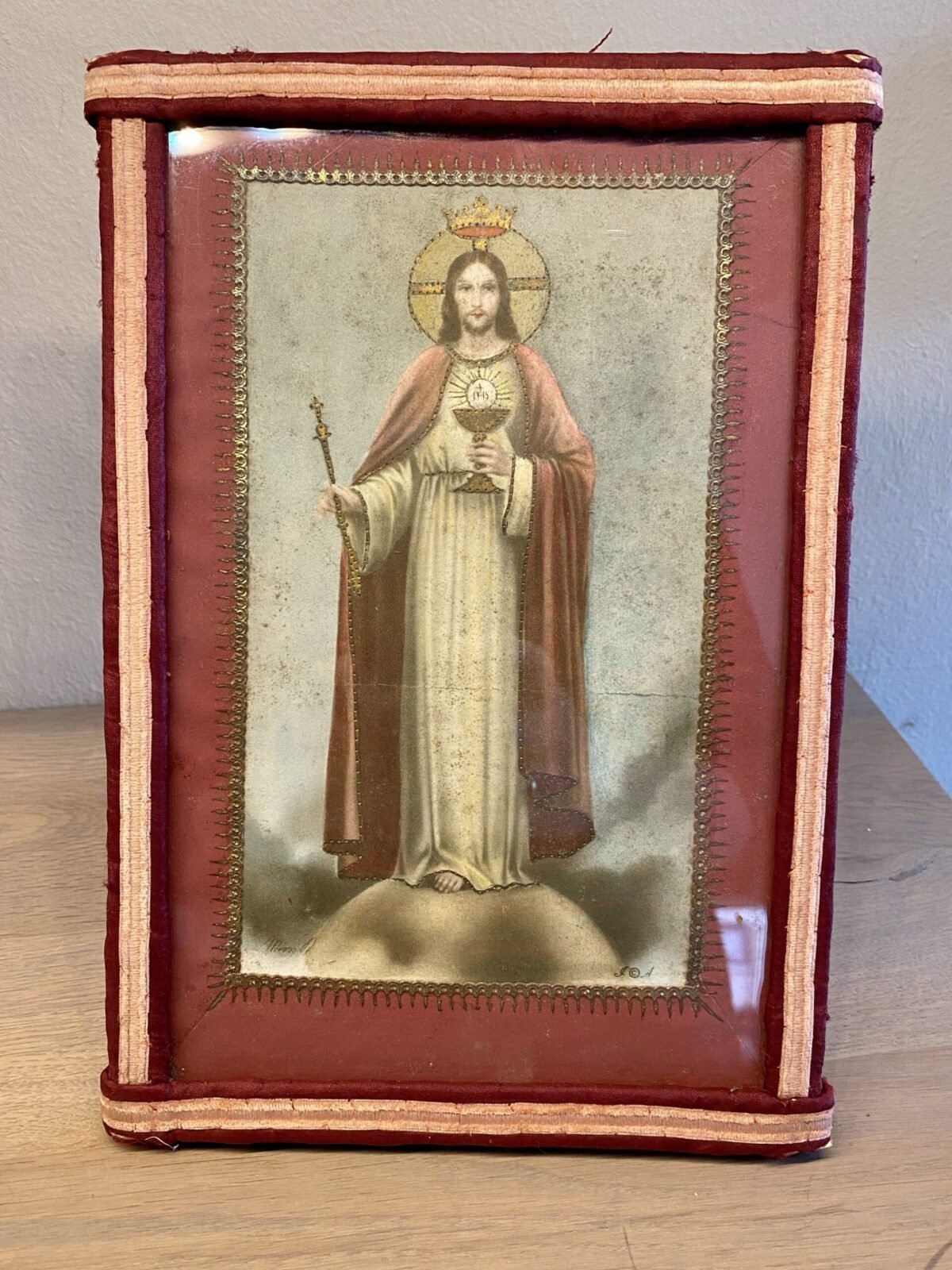 <p>Religieus plaatje in lijst (staand) - randen van rode en roze stof</p> - Brocante